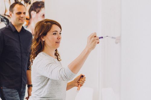 625dad2c390fcdca676dadf0_mammoth-team-2-p-500 woman writing on a dry erase board